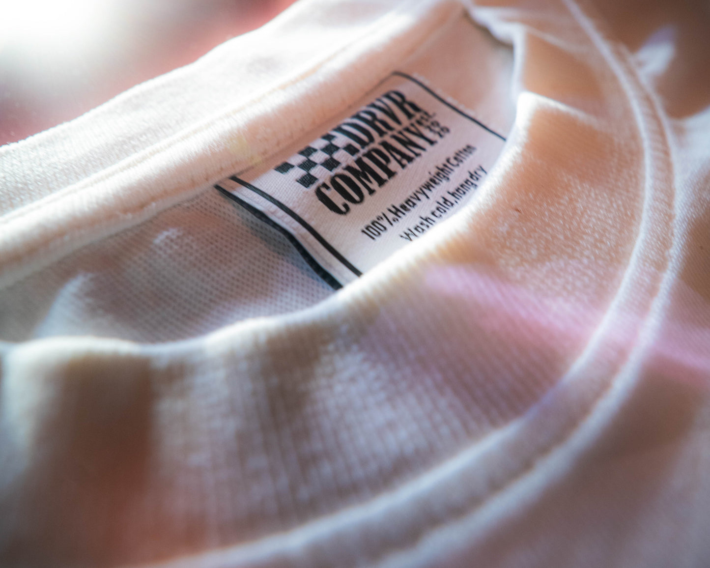 Close-up of a white t-shirt with a brand label on a blurred background