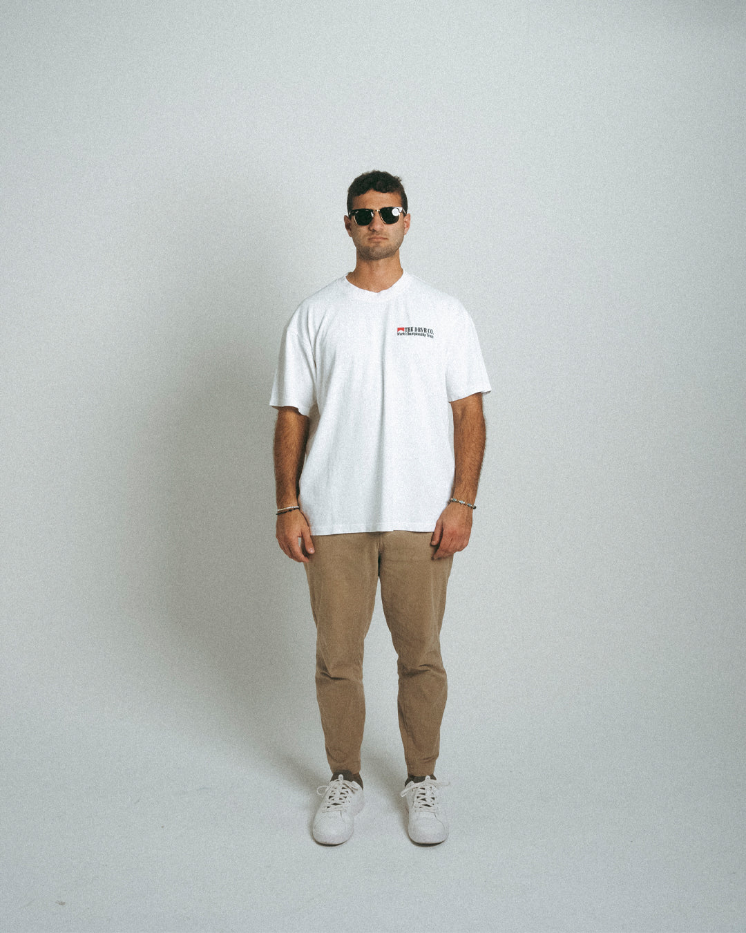 man wearing white Marlboro racing shirt with tan pants and sunglasses