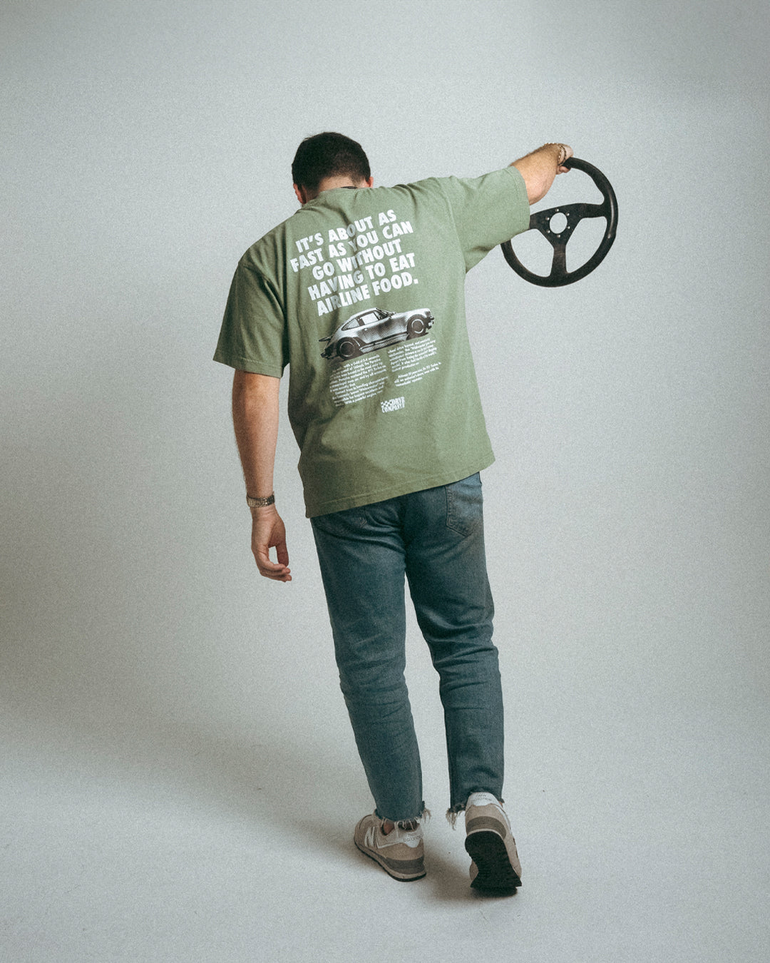 man posing with steering wheel in green shirt