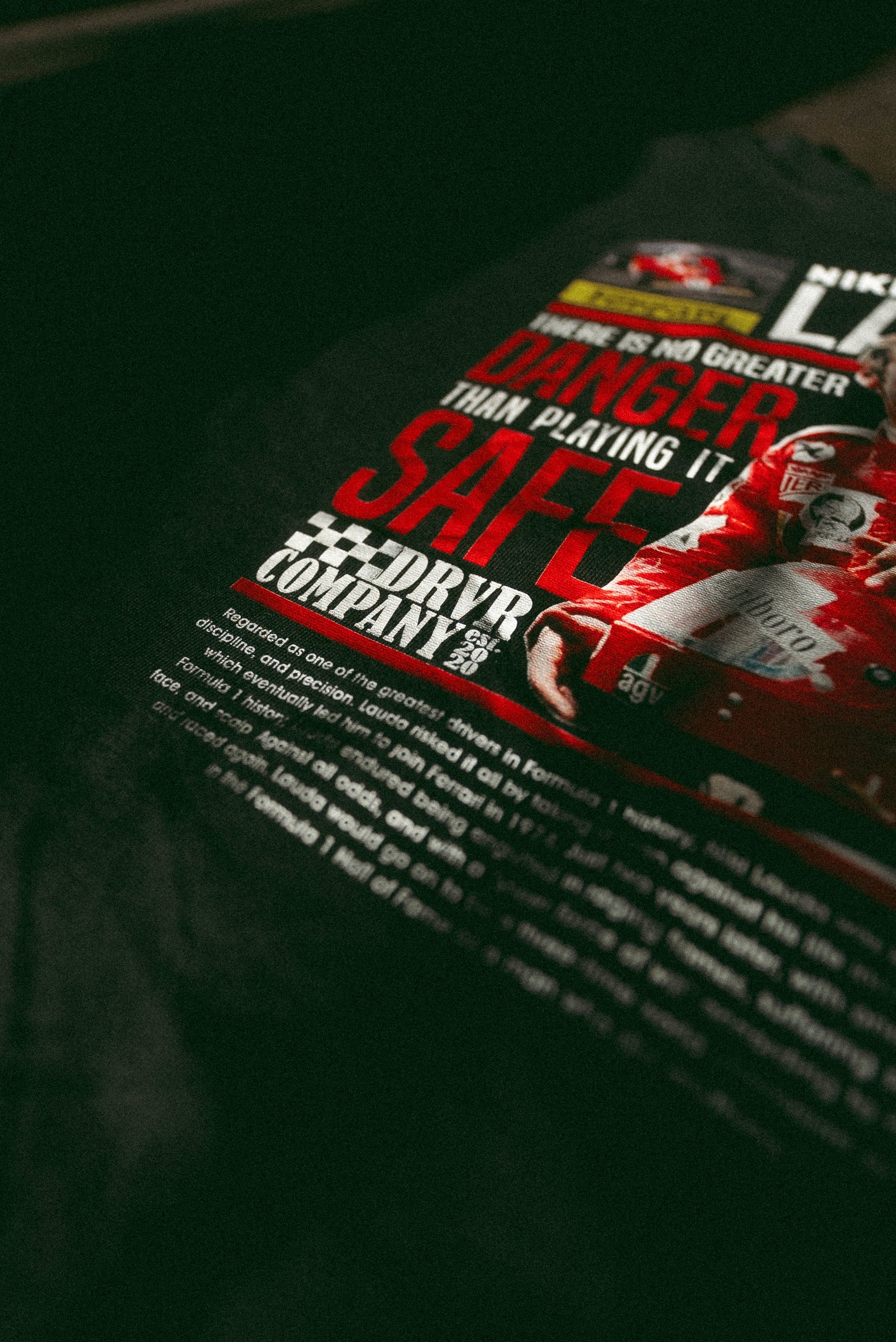 Black Heavyweight shirt on floor with red text