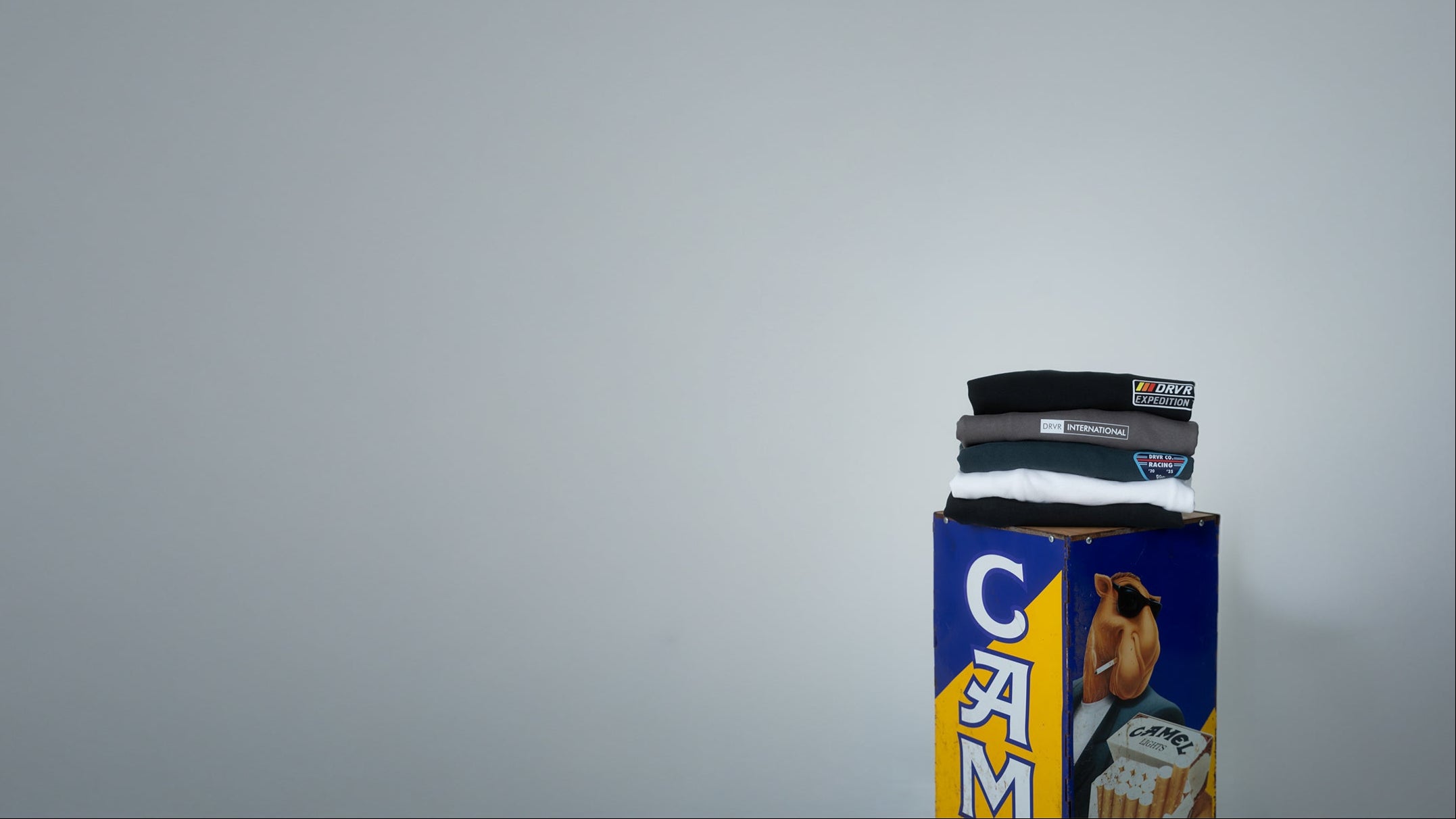 Candle with 'Cam' branding on a gray background