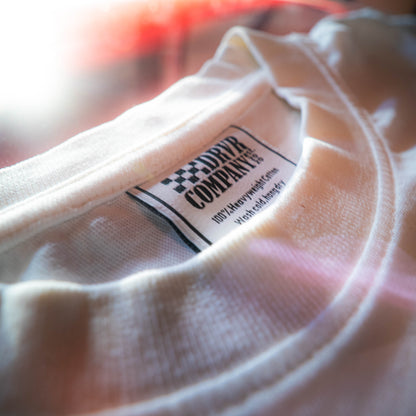 Close-up of a white t-shirt with a brand label on a blurred background