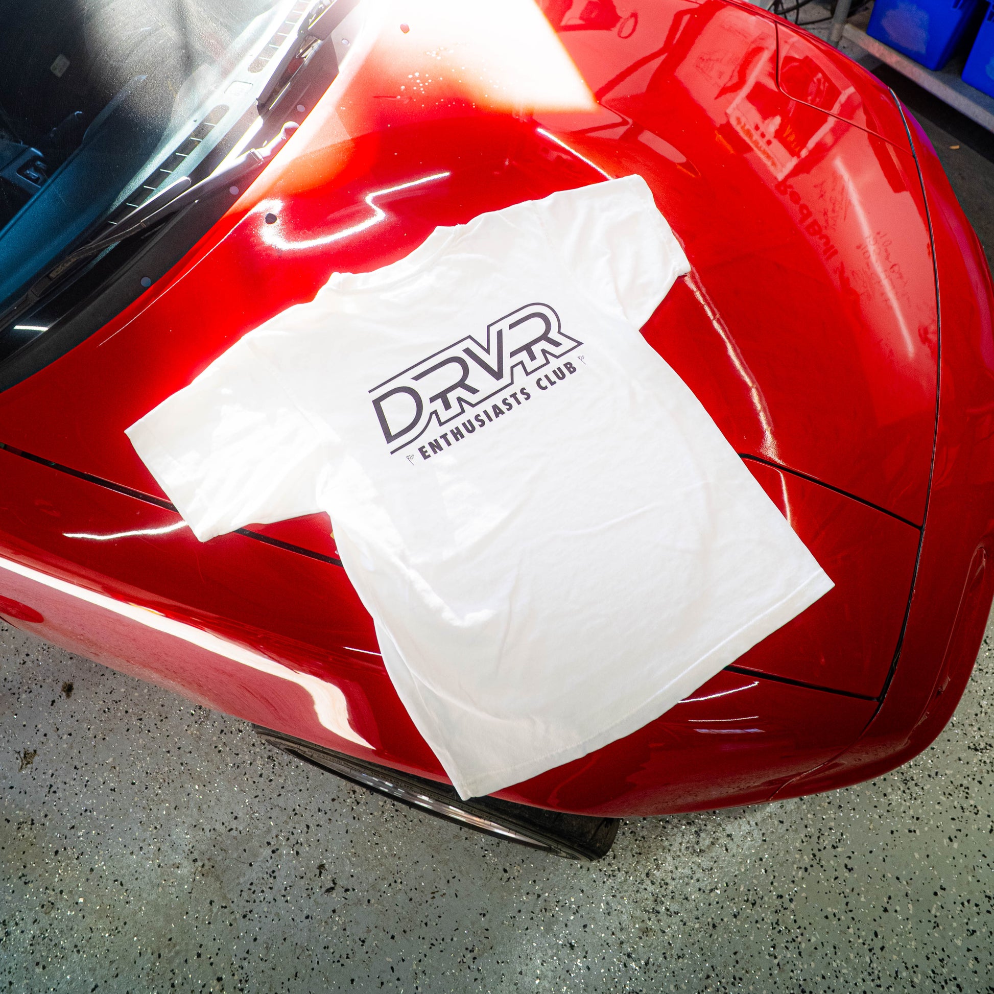 White shirt laying on red car