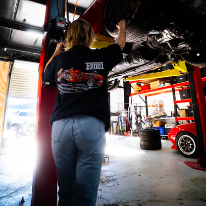 Person working on a car under a lift in a garage