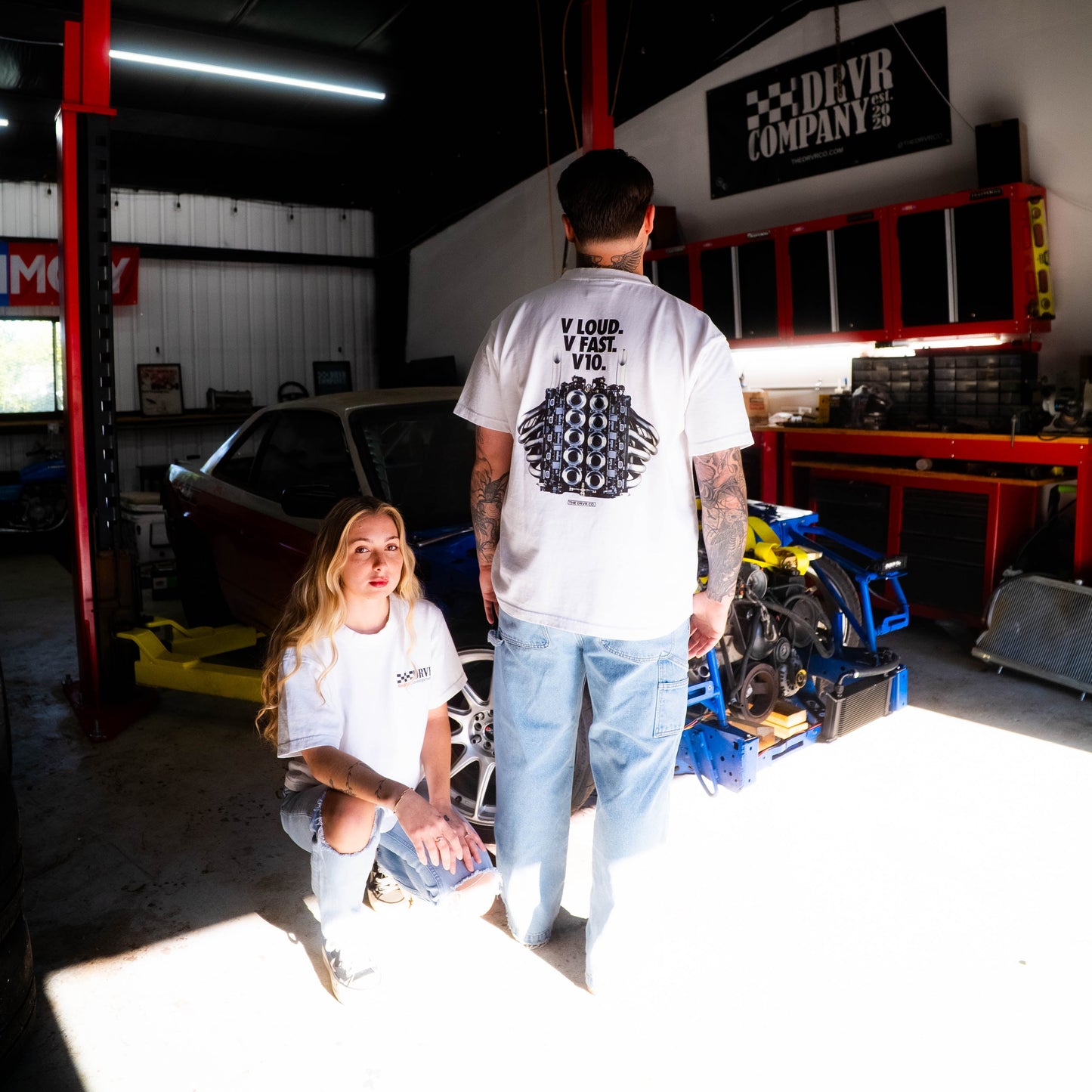 Two people in a garage with tools and equipment around