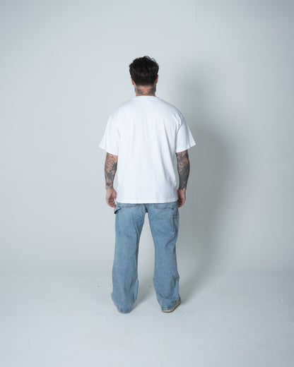 Person wearing a white t-shirt and light blue jeans on a plain background