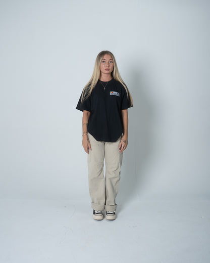 Person wearing a black t-shirt and beige pants on a white background